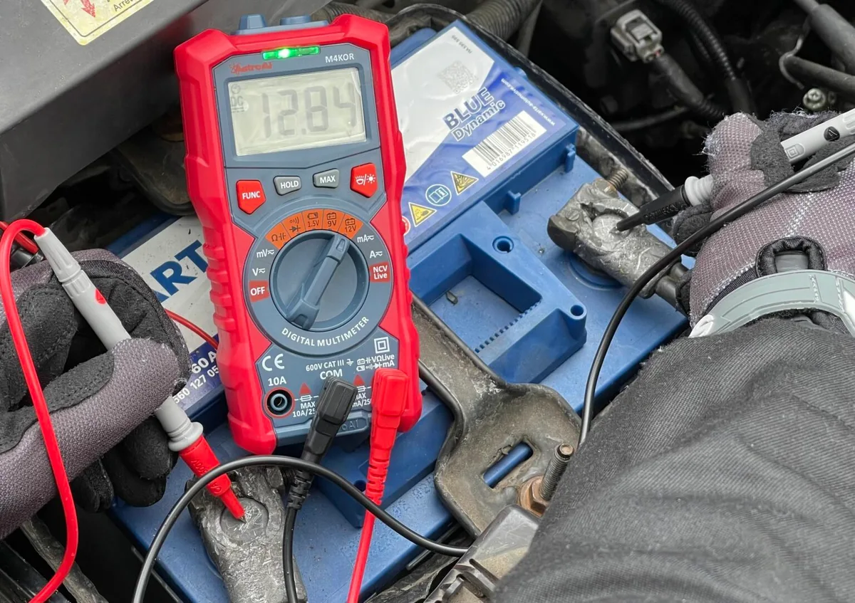 multimeter probes on car battery terminals